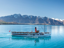 The TSS Earnslaw cruises across Lake Wakatipu with Remarkables in the background