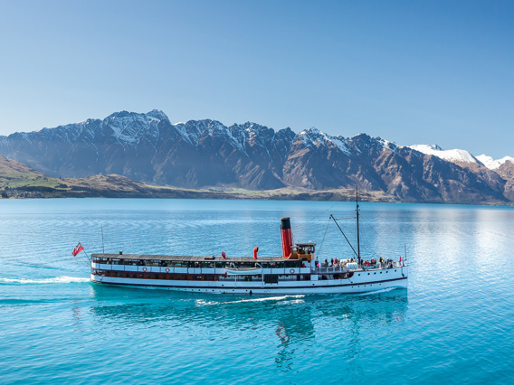 The TSS Earnslaw cruises across Lake Wakatipu with Remarkables in the background