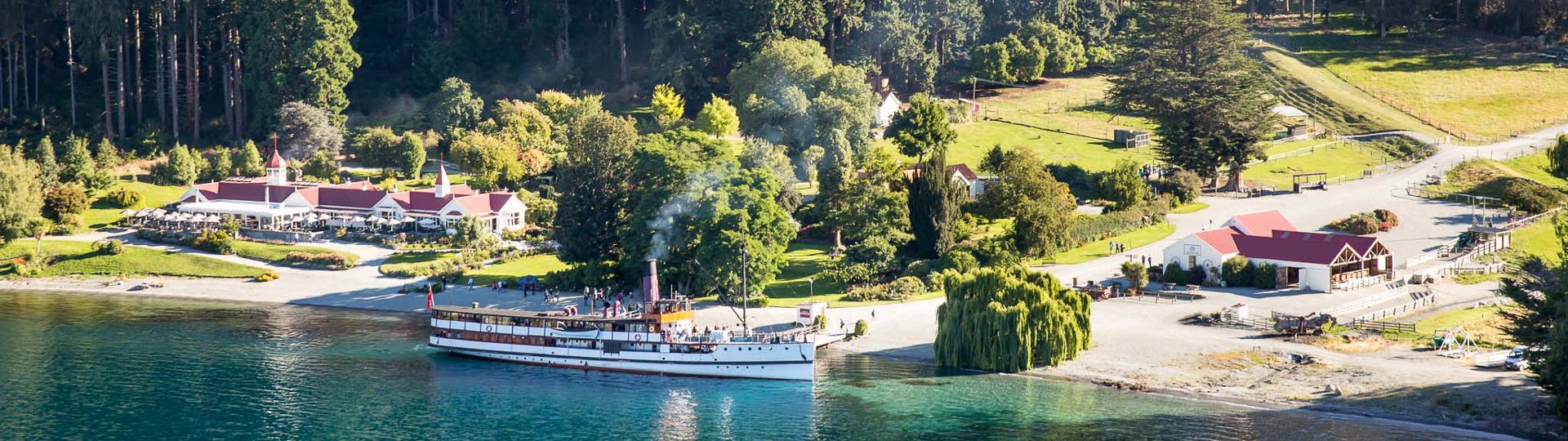 The TSS Earnslaw docked in front of the Colonel's Homestead at Walter Peak