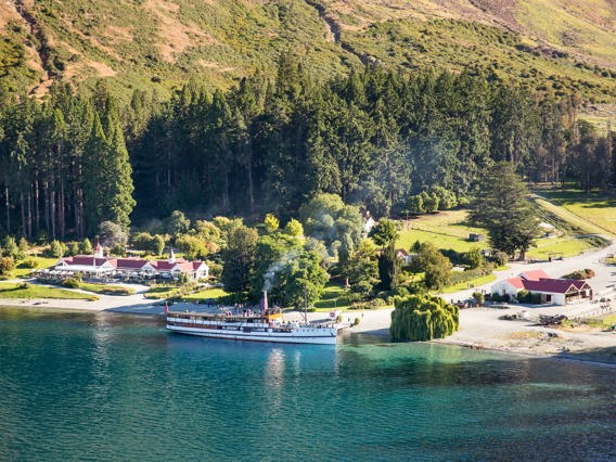 The TSS Earnslaw docked in front of the Colonel's Homestead at Walter Peak