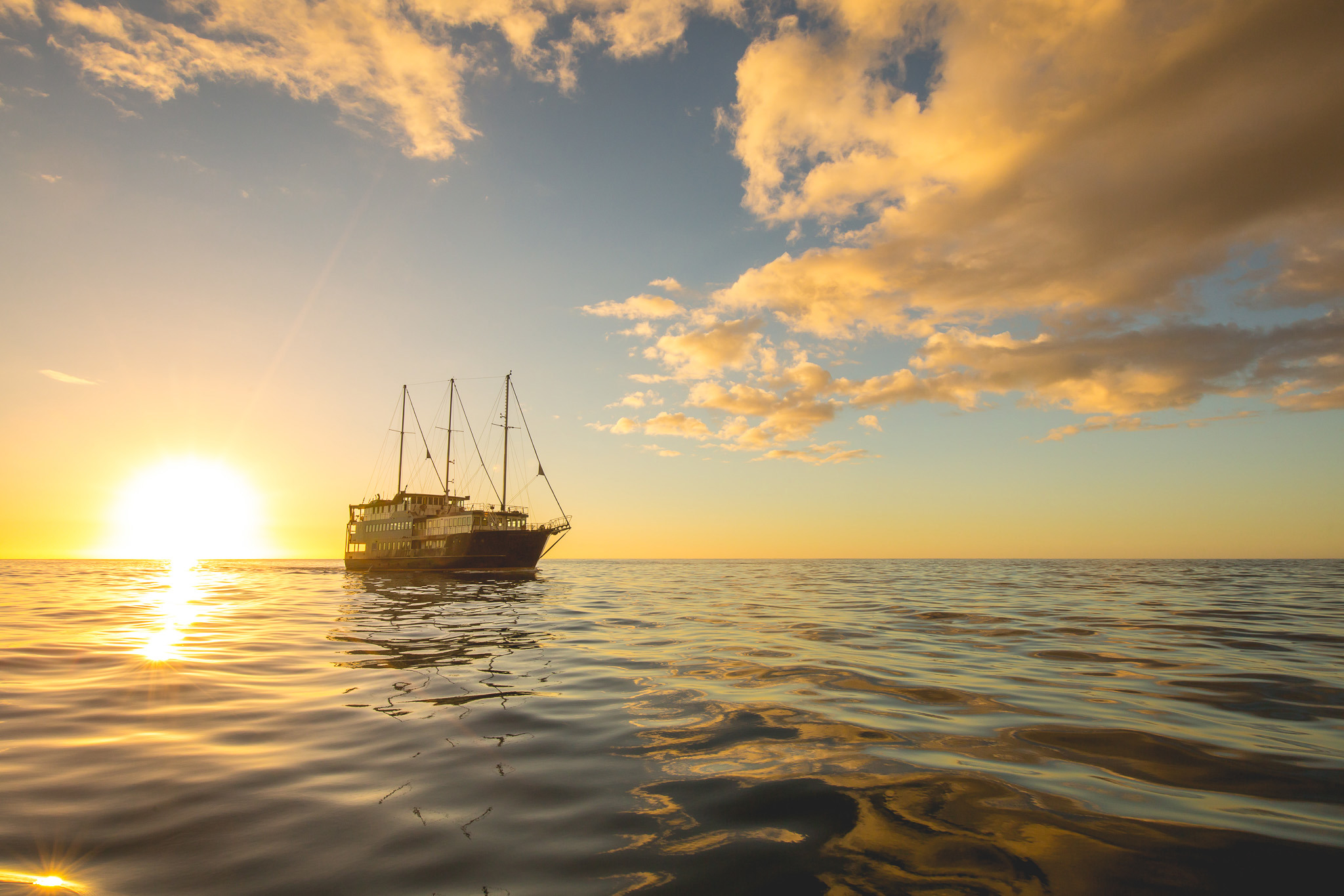 Boat sailing at sunset