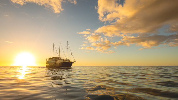 Boat sailing at sunset