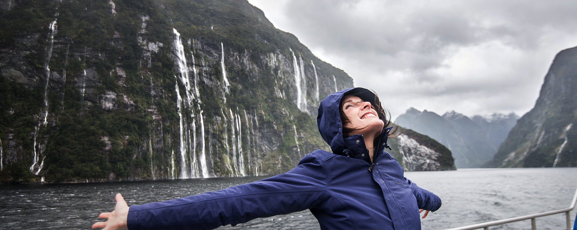 Woman enjoying the waterfalls in Fiordland National Park