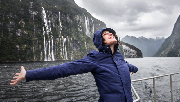 Woman enjoying the waterfalls in Fiordland National Park