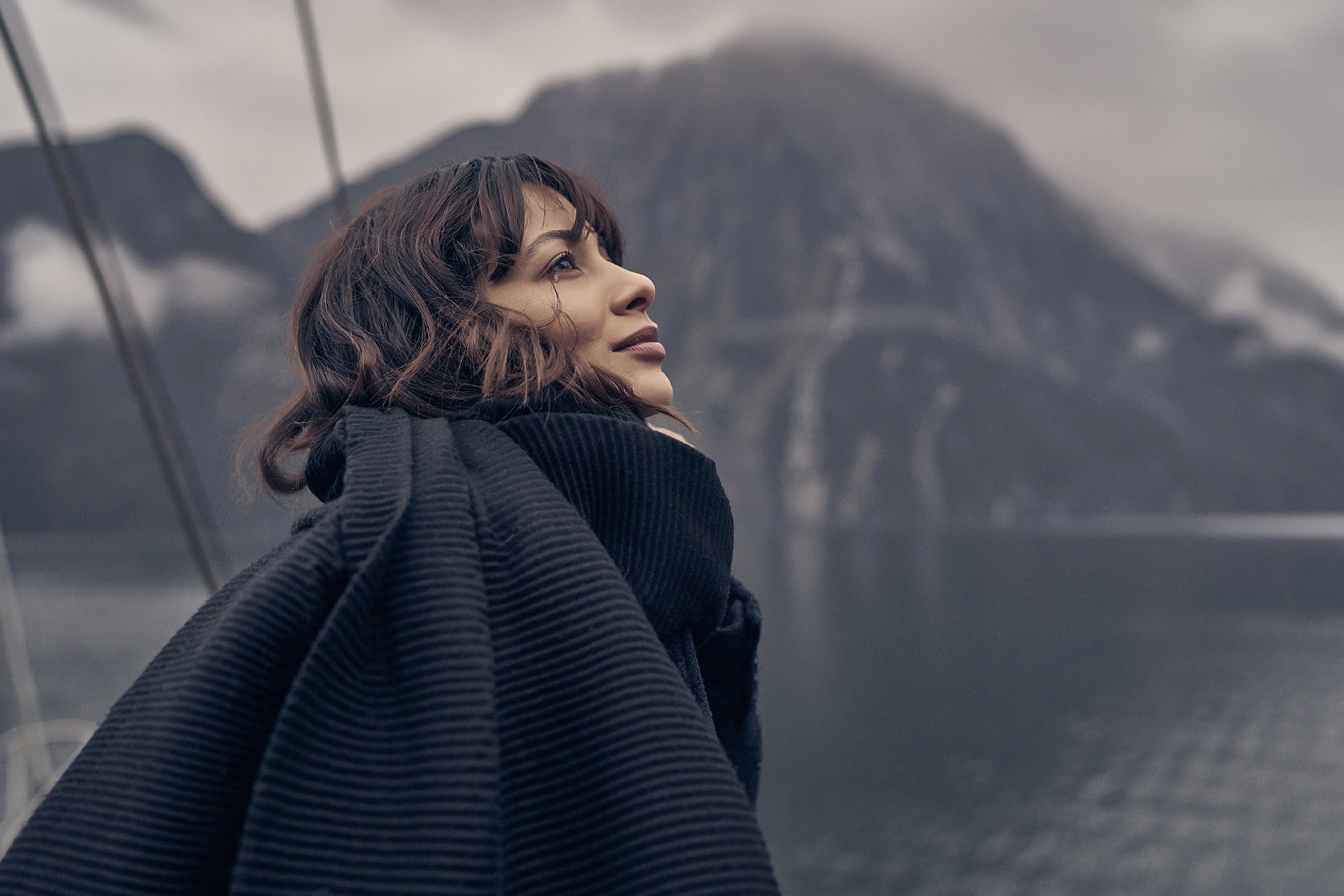 Woman looks at mountains in Milford Sound