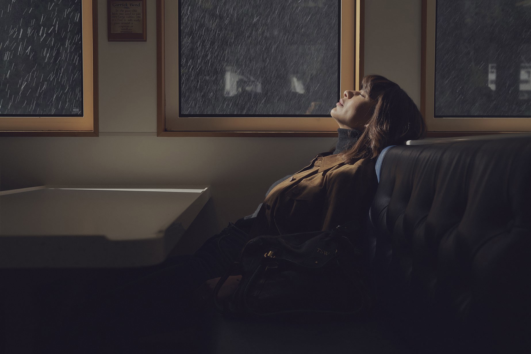 Woman sitting at window enjoying the rain