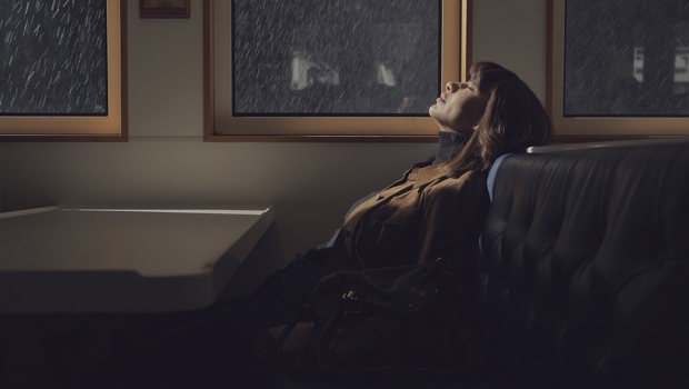 Woman sitting at window enjoying the rain