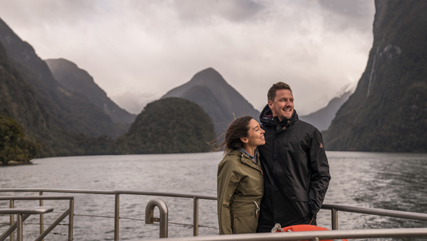 Couple on a boat enjoying the mountain views in Doubtful Sound