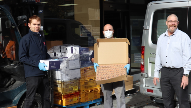 Salvation Army Queenstown Director of Community Ministries Lieutenant Andrew Wilson, Sam Neto (Salvation Army)  & Real Journeys Area Manager Jason Steele in front of some of the unloaded snacks 