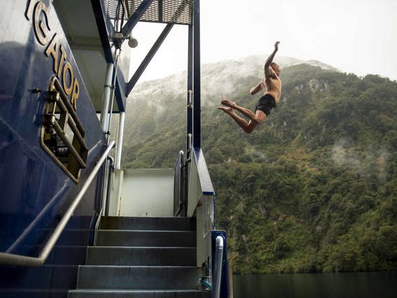 Man leaping off the Doubtful Sound Overnight Vessel into the water