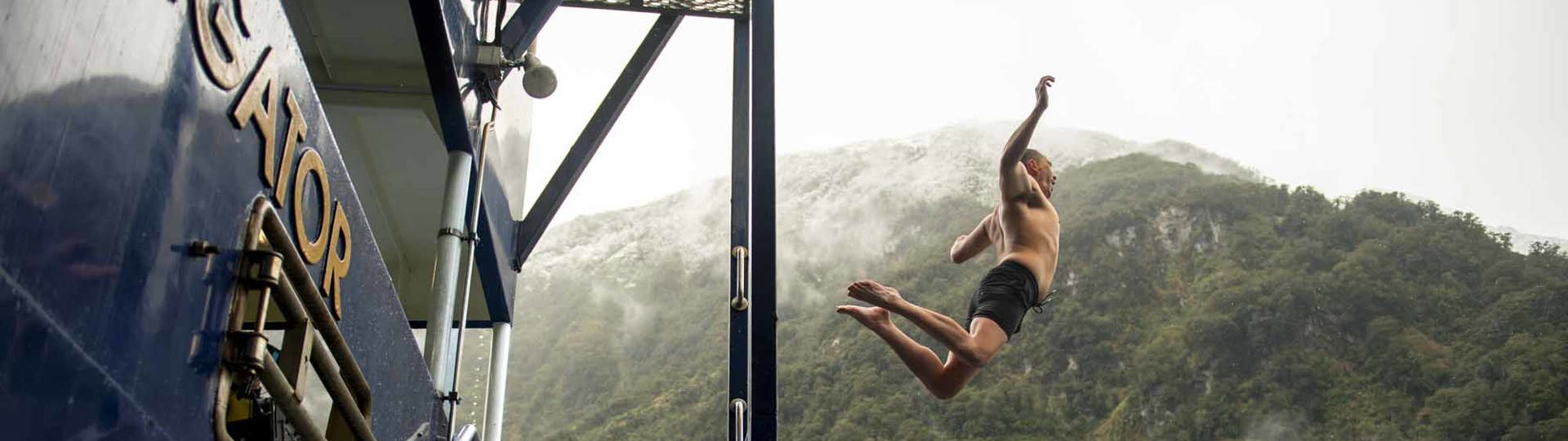 Man leaping off the Doubtful Sound Overnight Vessel into the water