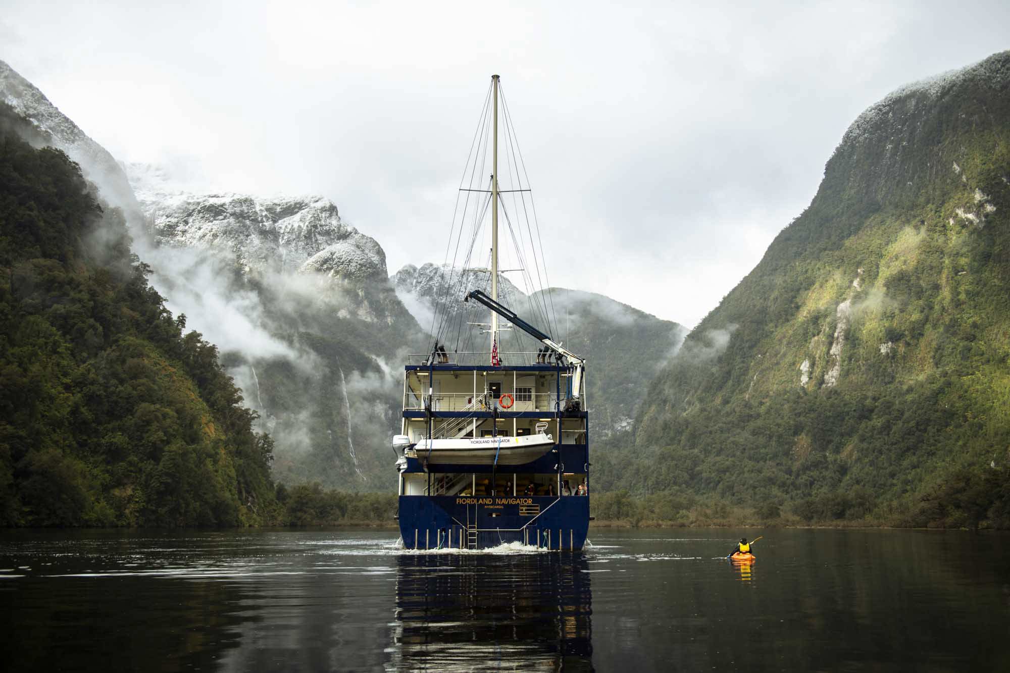 Kayaker on Doubtful Sound next to the Fiordland Navigator