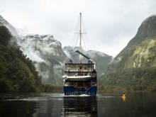 Kayaker on Doubtful Sound next to the Fiordland Navigator