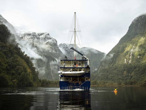 Kayaker on Doubtful Sound next to the Fiordland Navigator