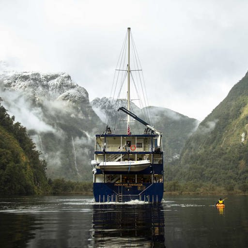 Kayaker on Doubtful Sound next to the Fiordland Navigator