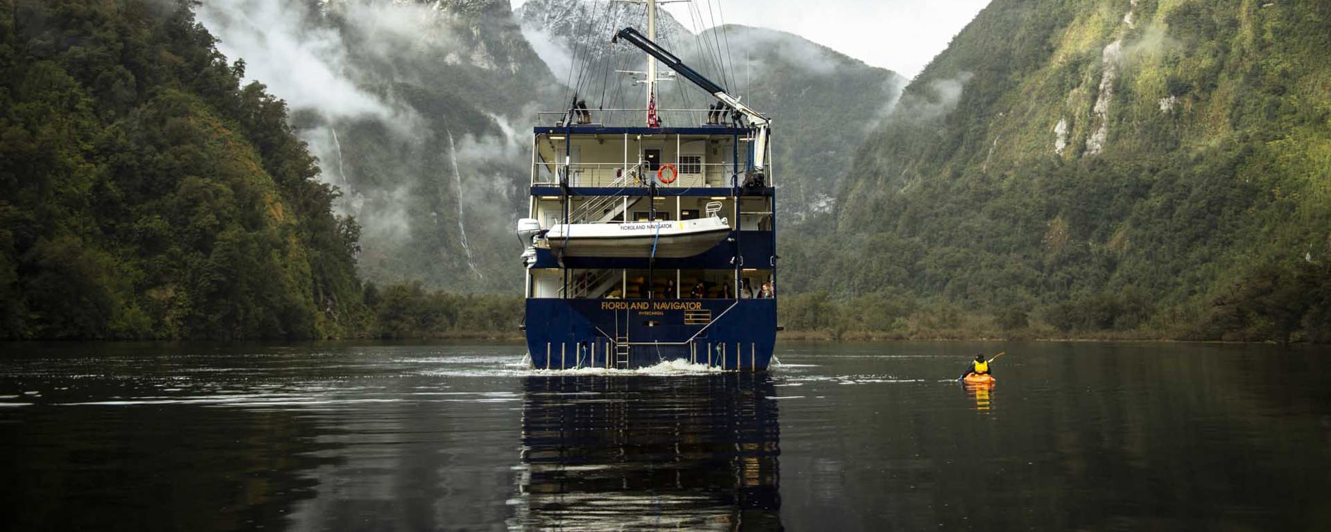 Kayaker on Doubtful Sound next to the Fiordland Navigator