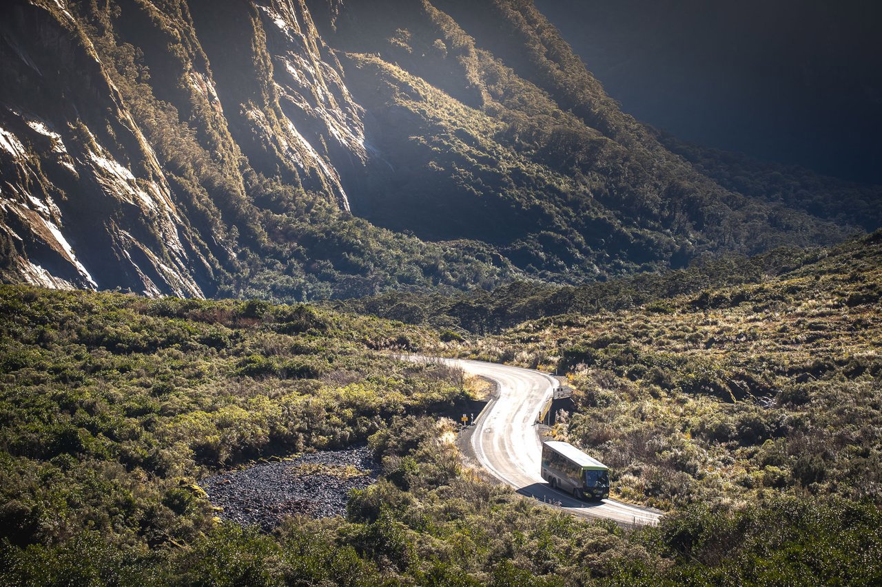 Coach driving to Milford Sound surrounded by mountains