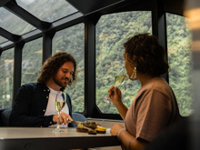 A couple enjoy a cheese board while cruising in Milford Sound on a premium experience 