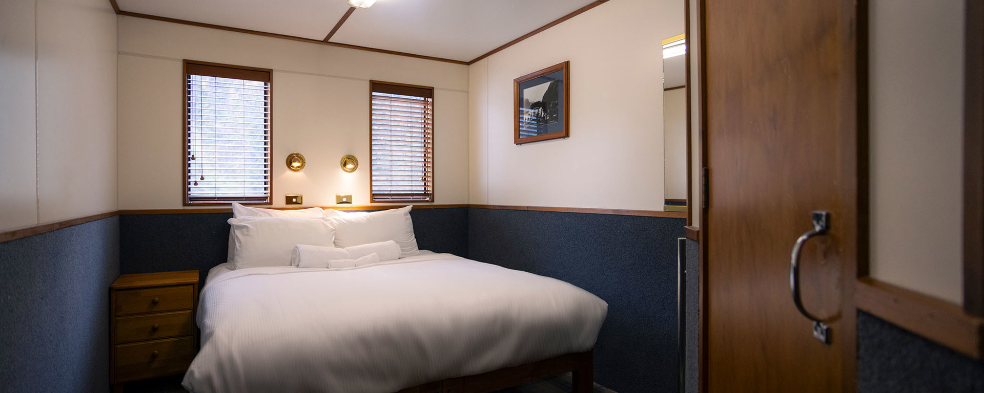 A wide shot of a bedroom onboard the Milford Wanderer overnight vessel