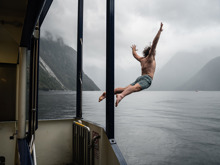 A man jumps from the Milford Wanderer into the moody water