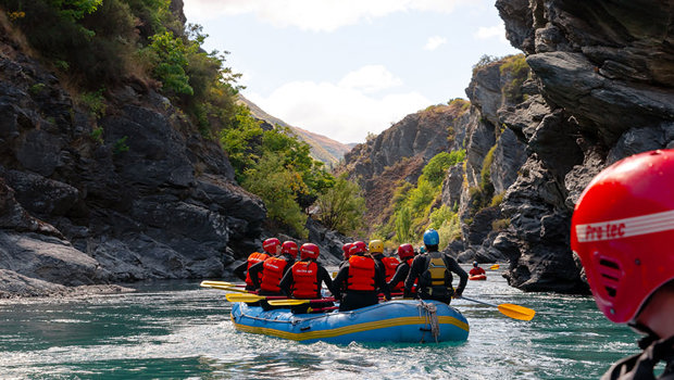 Several rafts paddling down the Kawarau river