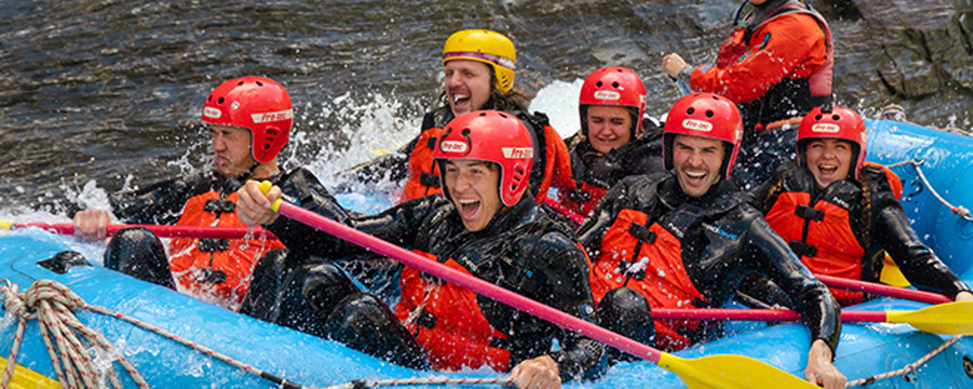 A group of rafters getting splashed with white water on the shotover river