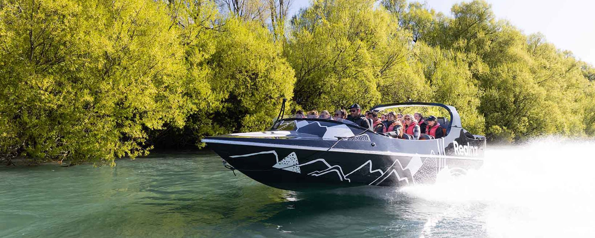 The queenstown jetboat zooming down a river