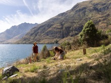 A woman plants a tree at the Walter Peak Eco Experience