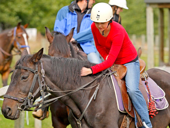 A woman strokes her horse at Walter Peak