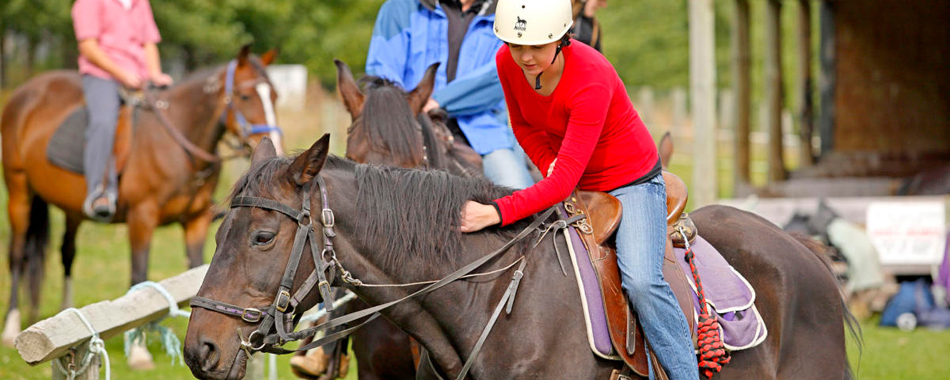 A woman strokes her horse at Walter Peak