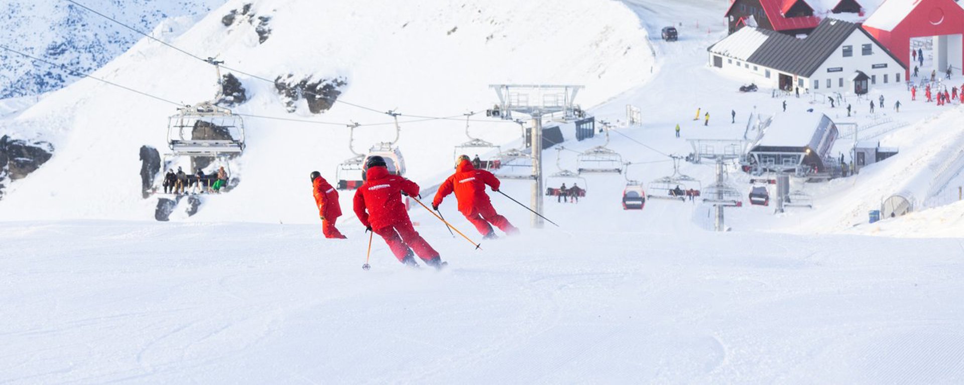 A trio of ski instructors skis down the piste at Cardrona Alpine resort