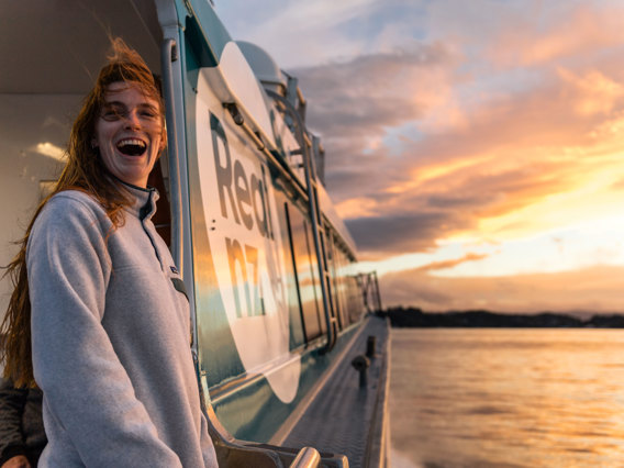 Woman on ferry at sunset