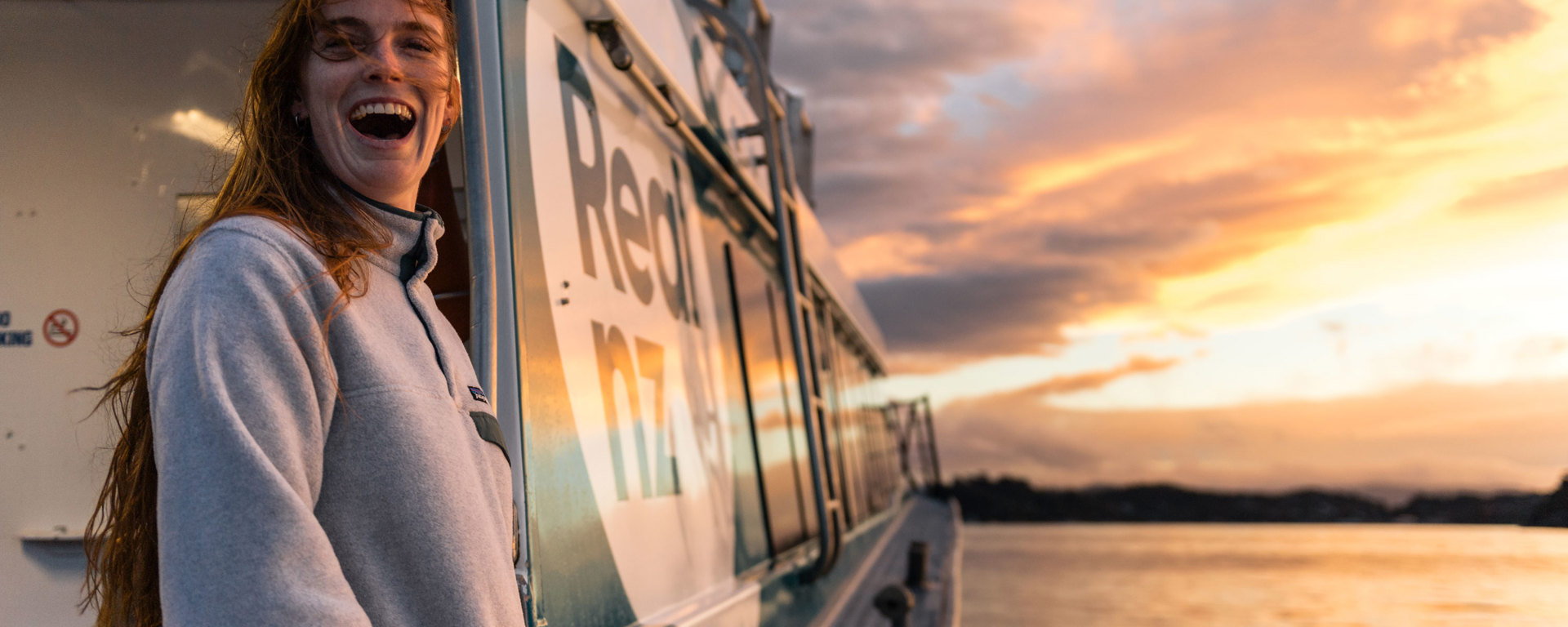 Woman on ferry at sunset