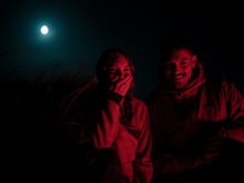 Couple searching for kiwi under a full moon