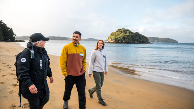 a guide showing a couple across ulva island beach