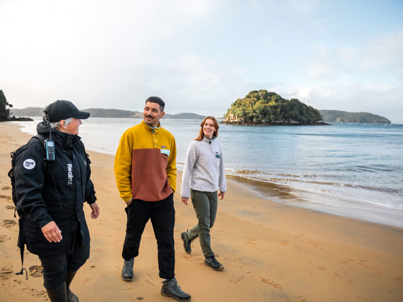 a guide showing a couple across ulva island beach