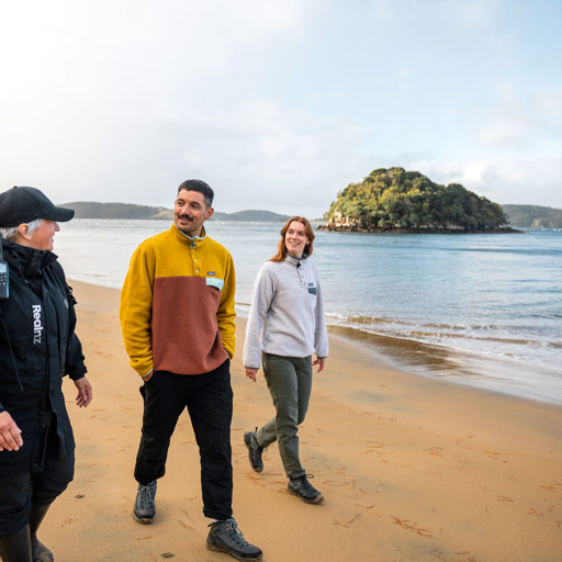 a guide showing a couple across ulva island beach