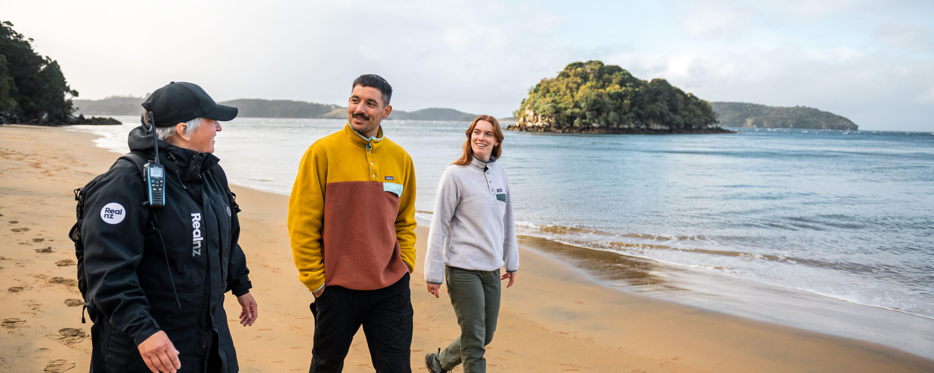 a guide showing a couple across ulva island beach