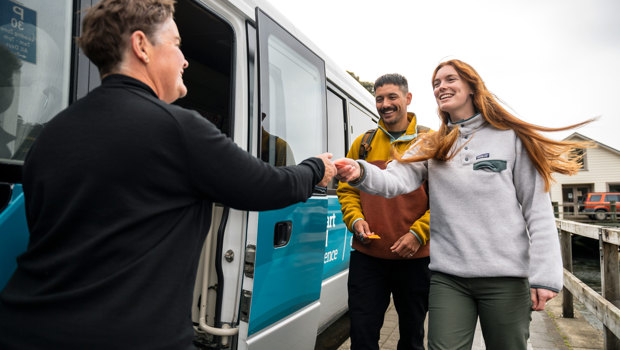 Bus driver greeting two guests