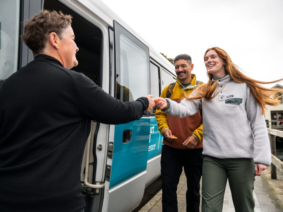 Bus driver greeting two guests