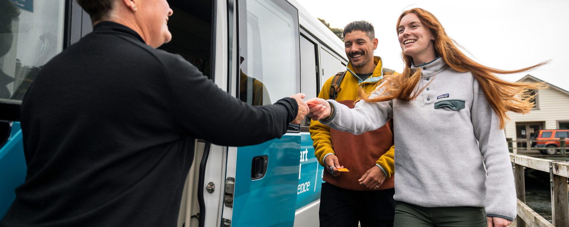 Bus driver greeting two guests