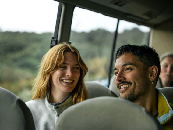 A couple smiling on village and bays coach