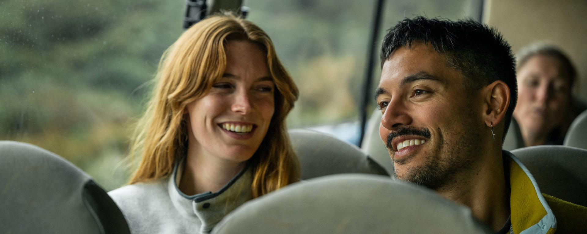 A couple smiling on village and bays coach