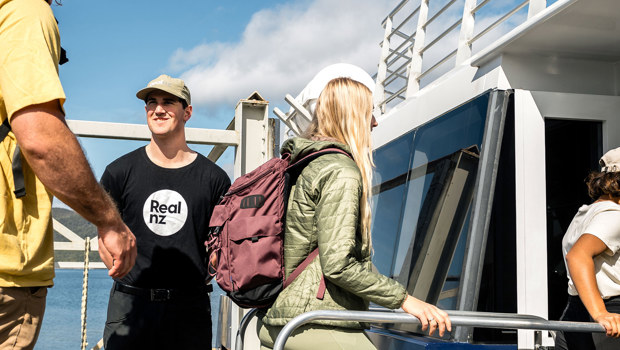 A cave guide welcomes passengers onto a boat in Te Anau.