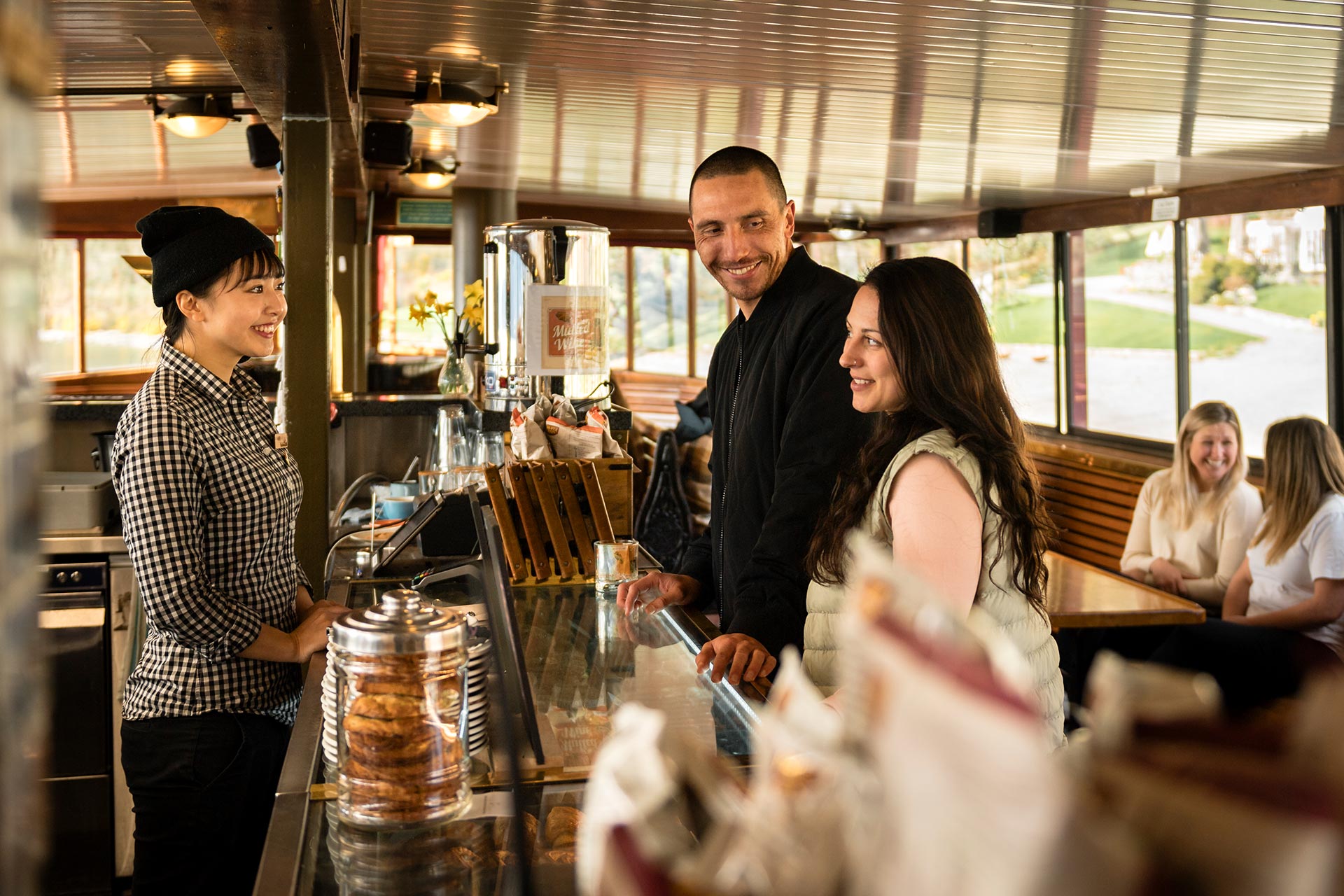 A waitress serves two customers at the bar on the TSS Earnslaw.