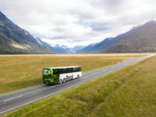 A bus drives through the Eglinton Valley on its way to Milford Sound.