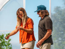 A couple explores Walter Peak’s Eco Experience greenhouse, harvesting fresh vegetables and enjoying a hands-on sustainable experience.