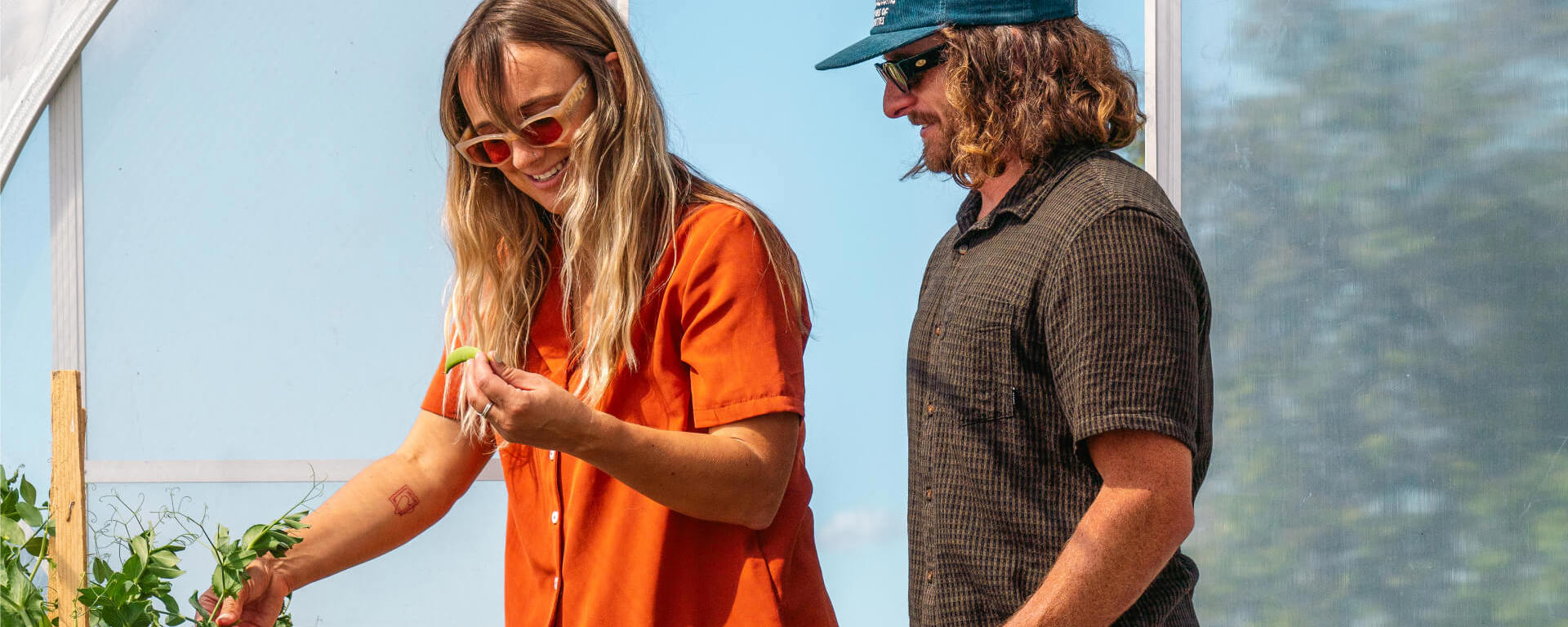 A couple explores Walter Peak’s Eco Experience greenhouse, harvesting fresh vegetables and enjoying a hands-on sustainable experience.