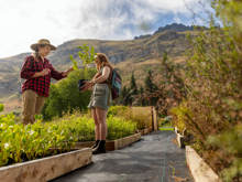 Guests at Walter Peak’s Eco Experience select native trees to plant, surrounded by lush gardens and breathtaking mountain scenery.